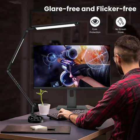 Man working at desk with LED Desk Lamp With Clamp Clip On, Sleek Design, 16 inch swivel head illuminating monitor