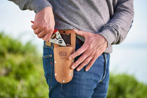 Person holding 8.3 Inch Pruning Shears With Aluminum Handles, Precision Bypass Blade, wearing them in a leather holster