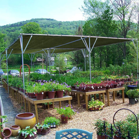 Outdoor garden setup with Beefy Weatherproof Canvas Tarp For Outdoors Highly Durable Waterproof Tarpaulin Shelter providing shade.