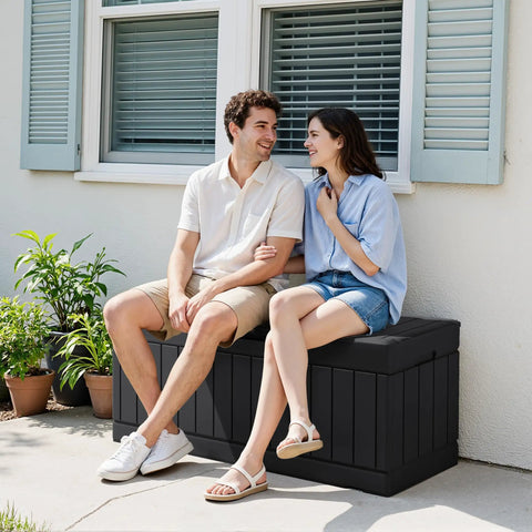 Two people sitting on a 78 Gallon Waterproof Resin Deck Box With Lockable Bench No Fuss Outdoor Storage, black resin rattan pattern.