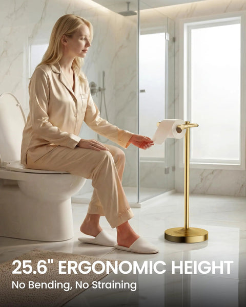 Heavy Duty Freestanding Toilet Paper Holder Stand In Matte Gold Frame Delivers Rock Solid Stability And Non Slip Floor Cushion For Slick Bathroom Upgrades And Hassle Free Roll Swaps with a woman reaching for paper.