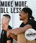 Two people enjoying smokes with text 'Smoke More, Roll Less,' highlighting 30-minute burn time of Mini Cannagar Mold And Cigar Roller Kit.