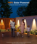 Family walking by wall with 8 Pack Solar Fence Lights With Warm White LED Spot Lens, Outdoor Waterproof Security Lighting