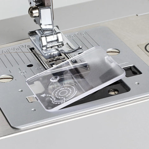 Clear plastic bobbin cover plate for Singer sewing machines; front view with presser foot and needle visible.