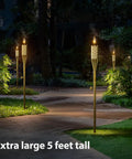 Bamboo Tiki Torches Outdoor Mosquito Repellent 12 Pack, 60 Inch Tall Garden And Backyard Lights, Citronella Oil Lamps illuminated on a path