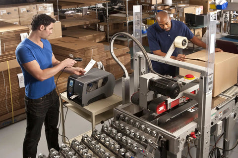 Heavy Duty Industrial Thermal Transfer Label Printer Built Different With A Rugged Metal Chassis on a warehouse workstation.