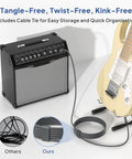 Rugged Quarter Inch TRS Guitar Cable 10ft 2-Pack connected to guitar and amp, with cable tie on floor.