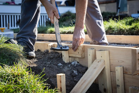 Builder using 16oz Titanium Framing Hammer With Magnetic Nail Holder And Smooth Face on wooden structure outdoors