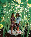 Two children standing among giant sunflowers grown from Sunforest Mix Sunflower Seeds Pack Of 100 For Giant 10 To 15 Feet Tall Sunflowers.