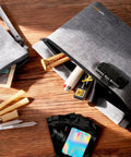 Grey smell proof bag with combination lock, odor proof container with carbon lining shown open on wooden surface, scattered items