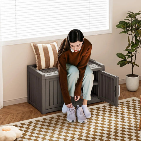 Weatherproof Outdoor Shoe Storage Cabinet With 2 Barn Doors And Adjustable Shelves And Waterproof UV Resistant Entryway Bench For Indoor Outdoor Use This Rugged Resin Shoe Organizer In Classic Grey, woman placing shoes in cabinet