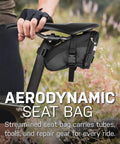 A cyclist attaching Aero Wedge Pack Small Strap Mount Seat Bag For Tubes And Tools Built For Cyclists With Reflective Trim to bike.