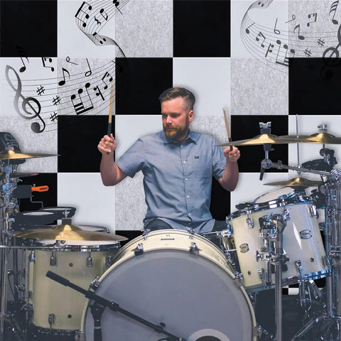 Drummer playing in front of Heavy Hitter Acoustic Wall Panels 12 By 12 Inches White Sound Absorbing Tiles, enhancing soundproofing.