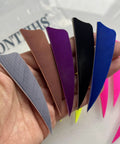 Person holding assorted colored archery fletching feathers, not the Archery Fletching 50 Pack Right Wing 3 Inch Natural Turkey Feathers.