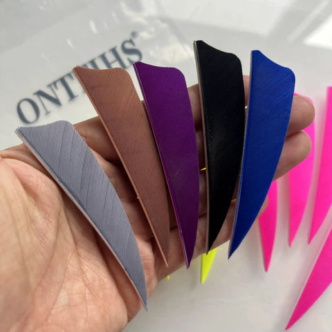 Person holding assorted colored archery fletching feathers, not the Archery Fletching 50 Pack Right Wing 3 Inch Natural Turkey Feathers.