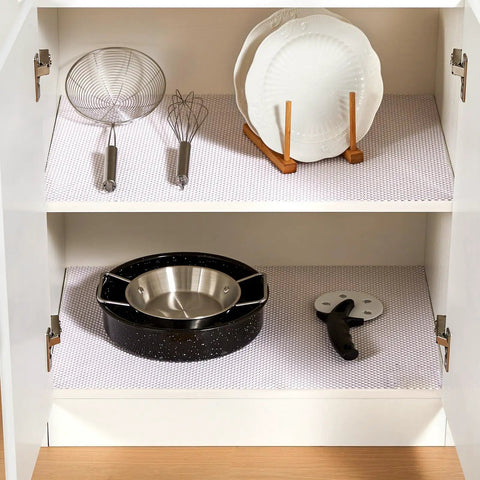 Top Shelf Nonslip Shelf Liner For Kitchen Cabinets And Drawers, White Non Adhesive Mat in a cabinet with pots and utensils.