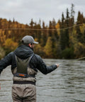 Angler using Stormshadow Fly Fishing Chest Pack With Waterproof Pocket on river, showing net slot and attachment points.