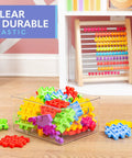 Colorful building blocks in clear plastic bin, wooden abacus in background, labeled 'Clear & Durable Plastic'