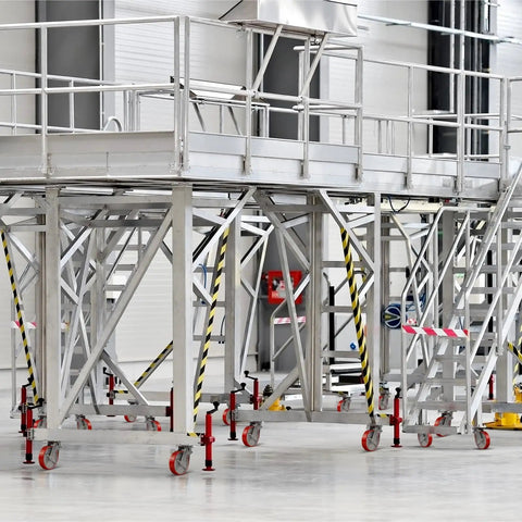 Heavy Duty 8x2 Inch Scaffolding Wheel Set Of 4 With 4400 Lb Capacity attached to metal scaffolding in industrial setting