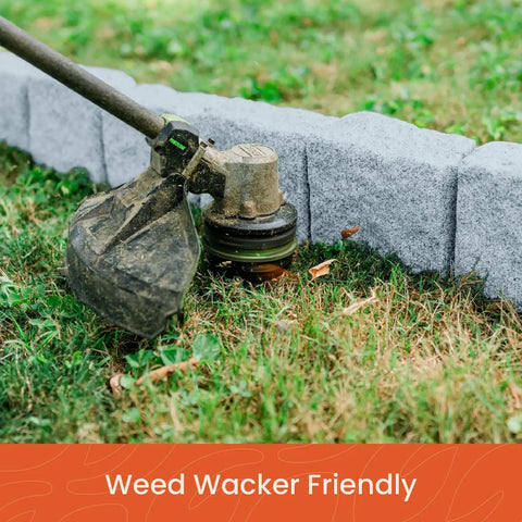 Close-up of weed wacker trimming grass along landscape edging kit with faux stone blocks for lawn borders and flower beds 10 pack with 20 spikes greystone look for no sweat easy install includes 48 inch long sections each section has 6 blocks.