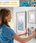 Woman using All In One Picture Hanging Kit With Level Tool And Sawtooth And Wire Hangers, Wall Mount Kit In Durable Hardware Case, 85 Piece Hanging Essentials For Quick Precise Picture Hanging And Leveling to hang frames on a wall.