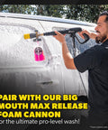 Person using a pressure washer with foam cannon attachment on a van
