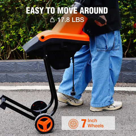 Person moving Beast 1800W Electric Wood Chipper Shredder For Yard Cleanup with 7-inch wheels, weighs 17.8 lbs, easy maneuverability.