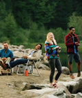 Group of friends fishing by a lake, one holding a Size 40 Spincast Fishing Reel With Right Hand Retrieve Built In Bite Alert All Metal Gears Stainless Steel Pick Up Pin Pre Spooled With 15 Pound Line Durable Black Reel For Freshwater Fishing