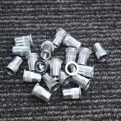335 Piece Rivet Nut Kit With Seven Metric Sizes M3 To M12, carbon steel zinc-plated nuts on a textured surface