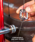 Hand using 4 In 1 Bicycle Spoke Wrench Kit With 3 Spoke Nipples Tools Plus Valve Core Remover And Valve Extender Holder on bike wheel.