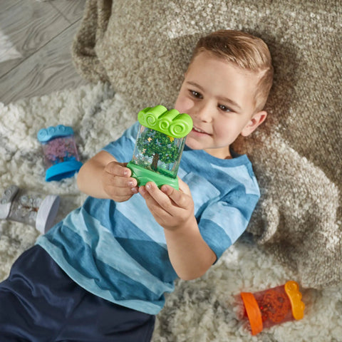 Child holding green spring Seasonal Sensory Tubes For Calming Kids, Chill Out Fidgets For Travel And School, Hands On Stress Relief Toy.