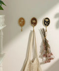Super Clean Set Of Three Straight Up Vintage Wall Hooks With French Garden Floral Details And Classic Scalloped Metallic Hardware For Entryway Organizing And Cozy Bedroom Vibes, displaying hooks with flowers and holding bags.