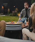 Group enjoying snacks on Surround Surface For Yukon Fire Pit Lid Durable Cold Rolled Steel Shield 34.5 Inch Diameter outdoors