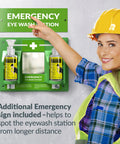 Front view of green wall-mounted emergency eye wash station with two 16oz empty bottles and mirror.