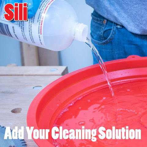 Pouring cleaning solution into collapsible silicone saw blade tray for holding solution for table saw blades up to 12 inches.