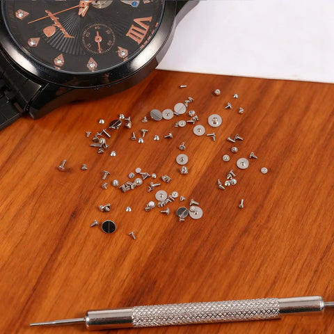 100 Piece Watch Screw Set With Micro Battery Clamp Screws on wooden surface with watch and screwdriver