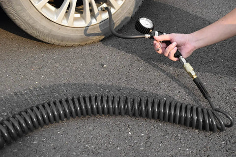 No Fuss Self Coiling Air Hose Polyurethane Recoil Design 3/8 Inch By 25 Feet connected to tire gauge on asphalt.