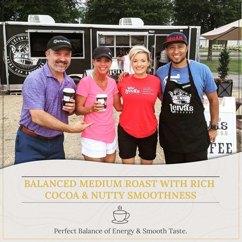 Group of four people holding coffee cups in front of a coffee truck with balanced medium roast banner.