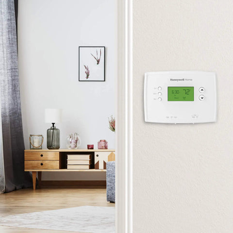 Smart 5-1-1 Day Programmable Thermostat With Early Start mounted on a home wall, displaying current temperature.