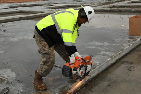 Worker in Ridgeline Full Brim Hard Hat With 4 Point Ratchet Fit Ultra Lightweight ABS Safety Helmet using saw on concrete
