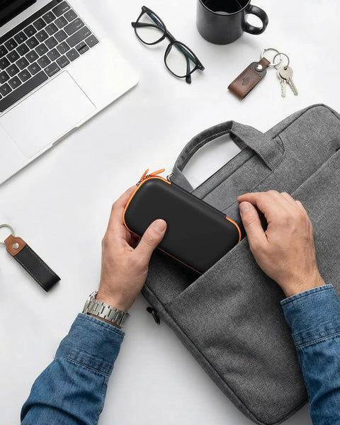 Person packing Rugged EVA Travel Case For SanDisk Extreme Portable SSD And Pro Portable SSD 500GB To 8TB into a laptop bag.