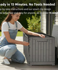 Person assembling 120 Gallon Outdoor Storage Box For Patio And Backyard Heavy Duty Resin Deck Box Built To Last With Reinforced Stainless Steel Support Waterproof And UV Resistant Weatherproof Storage For Cushions Garden Tools And Pool Accessories Grey on patio.