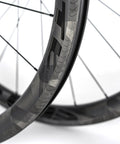 Close-up of 700C Road Bike Carbon Wheelset with 40mm UD X Weave Aero Rims and Rim Brake Surface, showing weave pattern.