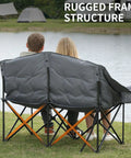 Couple sitting on Beast Mode Double Camping Chair With Cup Holders And Carry Bag, Heavy Duty Padded Folding 2 Person Outdoor Couch, Grey