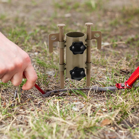 User securing tent with Beefy Adjustable Tent Stake Hammer Set With Aluminum Poles And Sand Stakes on grassy surface.