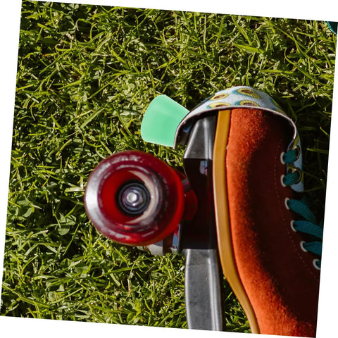 Quad skate with light green PU toe stop on grass. Toe Stop Replacement Pair For Quad Skates With PU Brake Pads No Fuss Install.