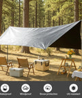 Heavy Duty Waterproof Tarp 10 By 10 Feet 16 Mil used as shelter in a forest camping setup, showing silver and black sides.
