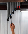 Hand reaching for zip tie on Magnetic Base Cable Tie Organizer With 250 Zip Ties And Cutter mounted in garage
