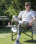 Man sitting on Oversized Directors Camping Chair Set Of 2 Built To Haul 600 Lbs Capacity Heavy Duty Folding Outdoor Chairs with side table.