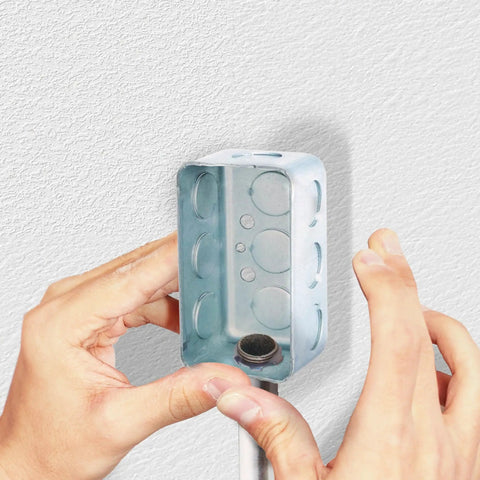 Hands installing Tough As Nails 3/4 Inch Rigid Conduit Lock Nut in a metal junction box for IMC tube mounting.